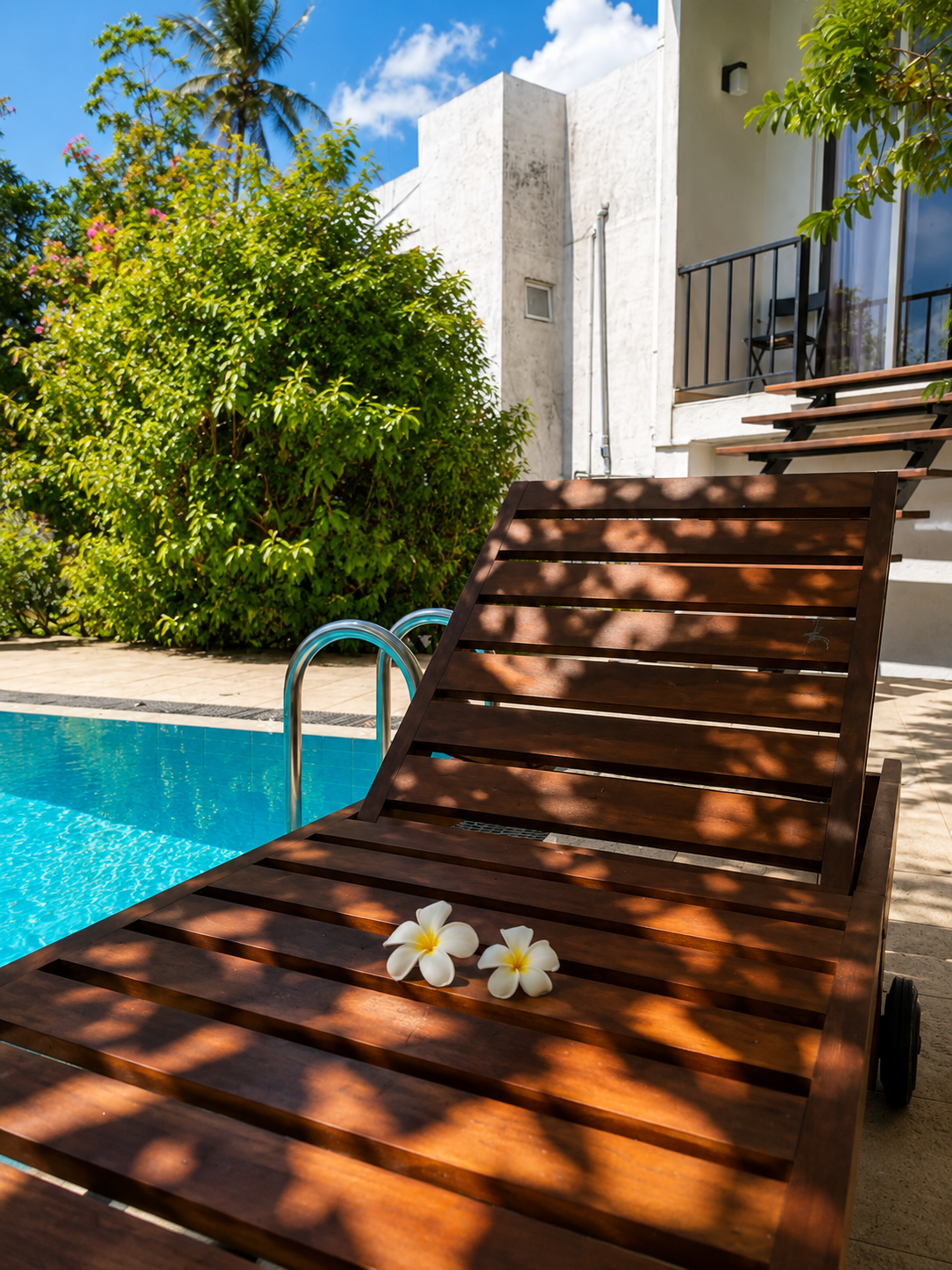 The pool at Oak Residencies, framed by palm trees at golden hour
